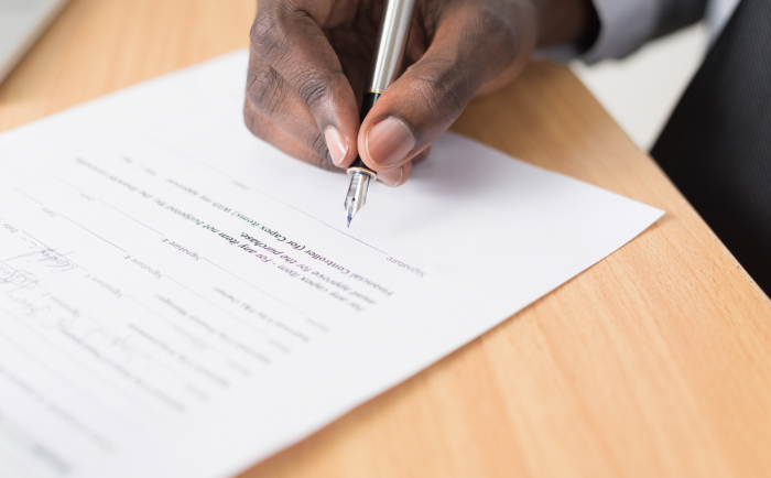 A person signing a contract.