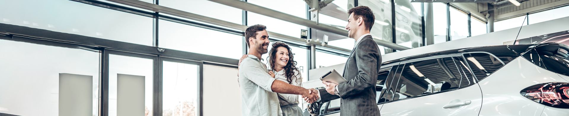 Excited couple shaking hands with loan officer 