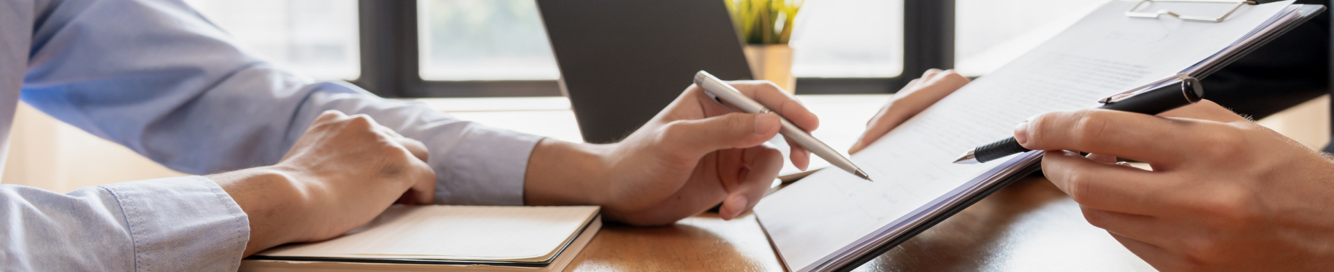 Person working at desk with pen in hand