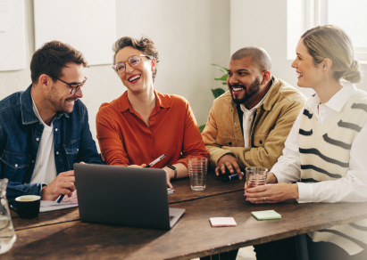 Group of people meeting at a table with a computer