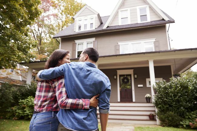 Two people walking up to new home 